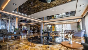 A spacious lobby with a polished marble floor, a central round table with a vase of flowers, and seating areas with striped upholstery. - Hierapark Thermal & Spa Hotel (Denizli)