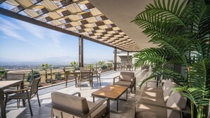 An outdoor terrace with a view of the city, furnished with tables and chairs, and a pergola providing shade. - Hierapark Thermal & Spa Hotel (Denizli)