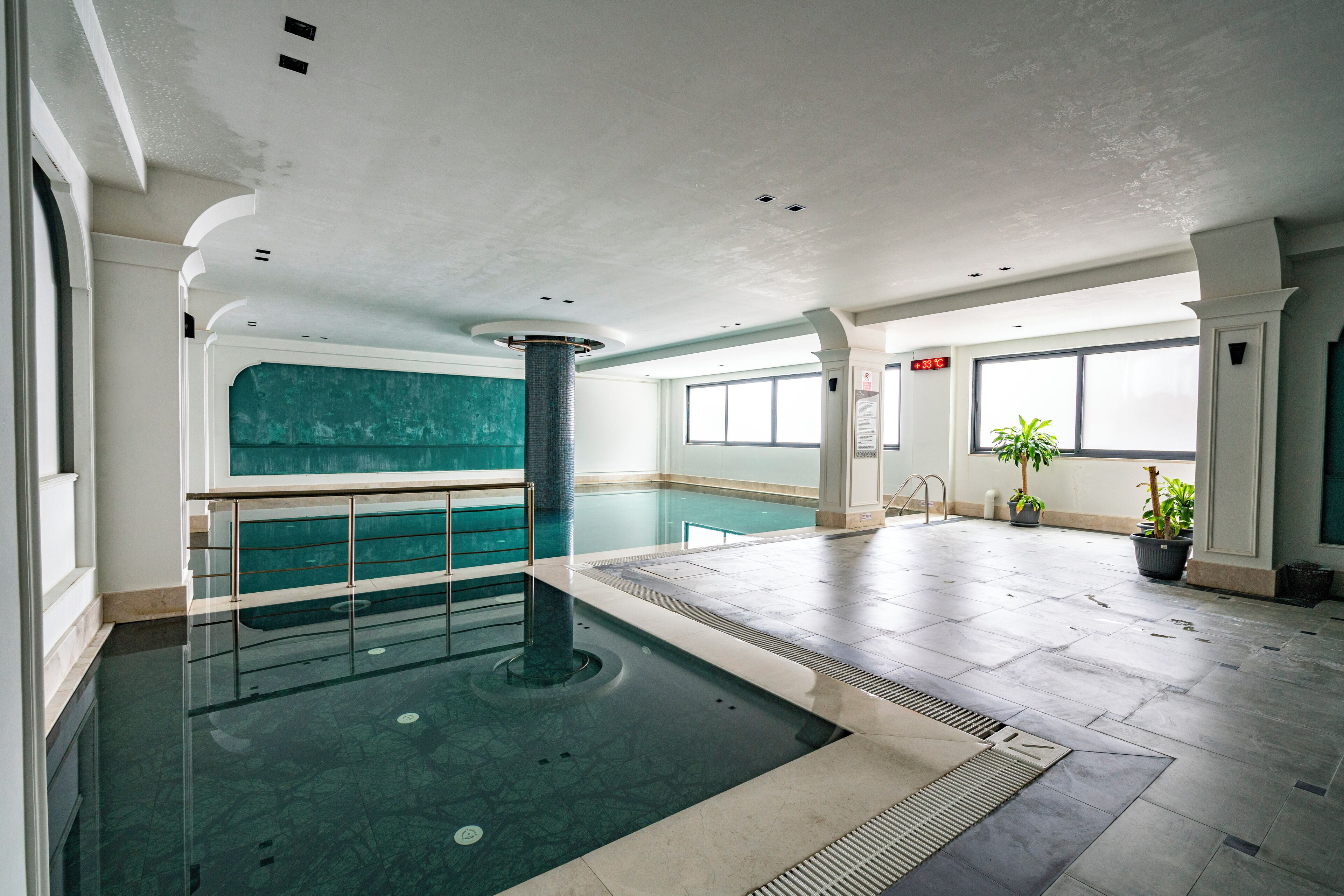 Una piscina interior espaciosa con vistas despejadas al techo y un ventanal grande.