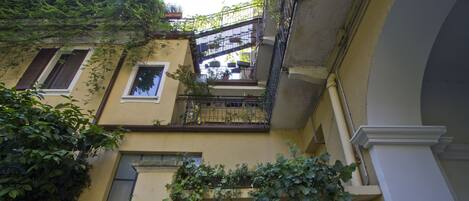 Un edificio con varios balcones, algunos adornados con plantas y flores.