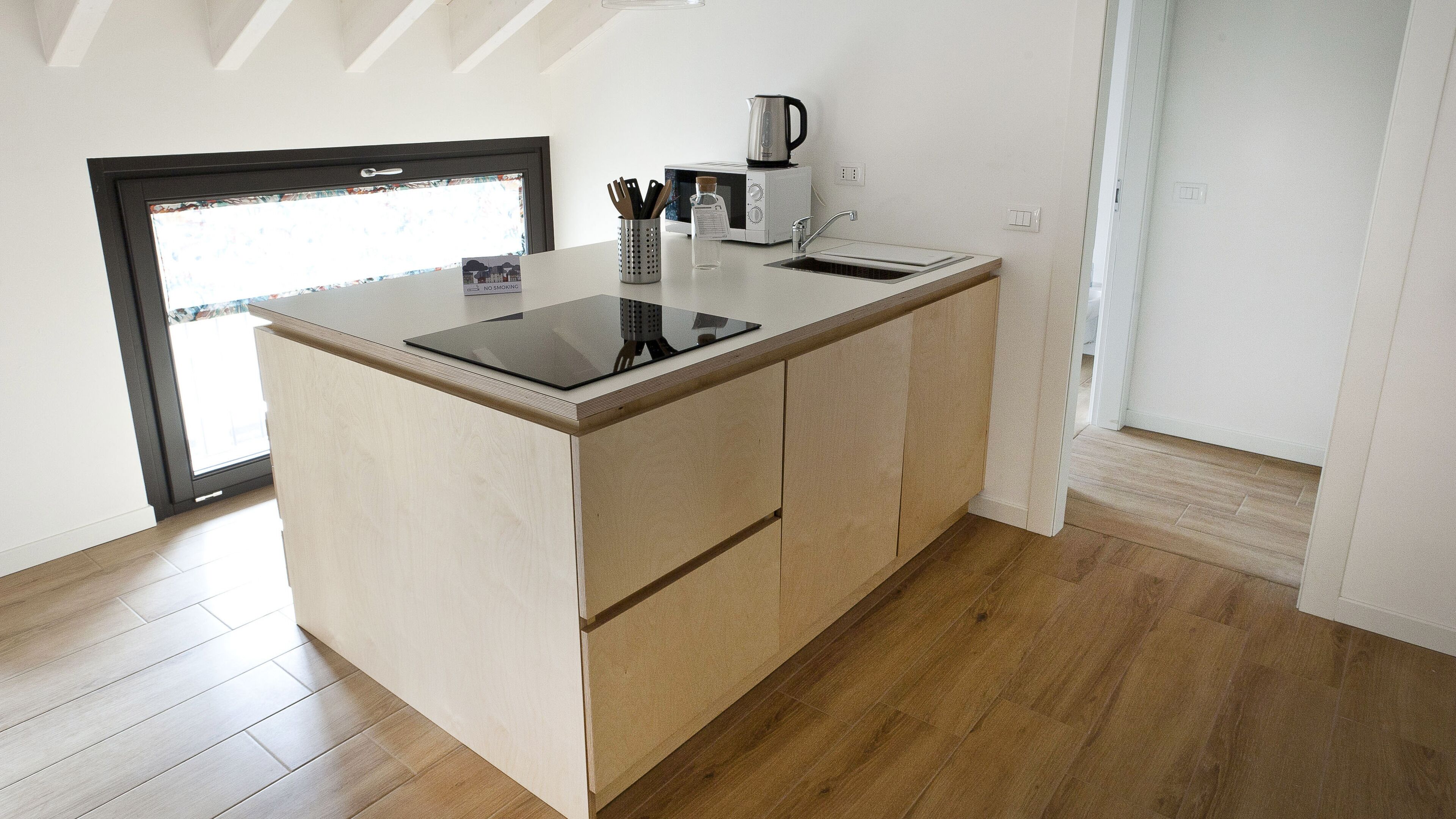 Una cocina moderna con una isla integrada, electrodomésticos de acero inoxidable y vistas al exterior.