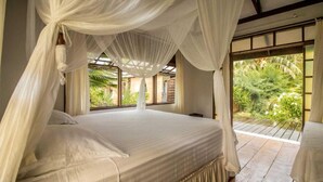 Un dormitorio con una cama grande, ropa de cama blanca y dosel.