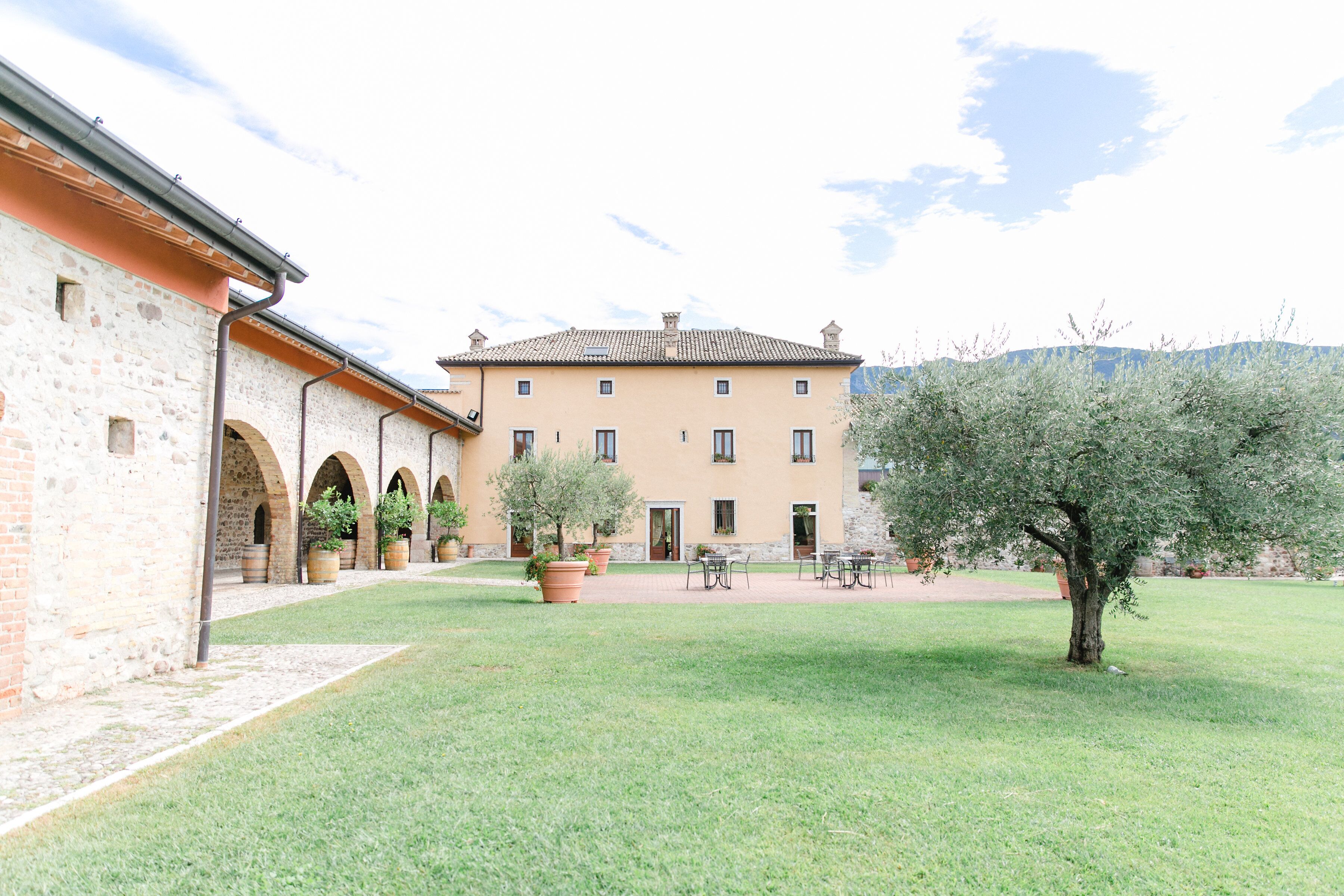 Un cortile con un edificio caratterizzato da porticati e sedute all'aperto.