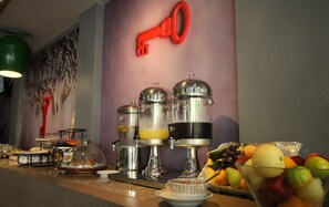 A breakfast bar with various food items and a key-shaped decoration on the wall. - Rooms Republic (Krabi)