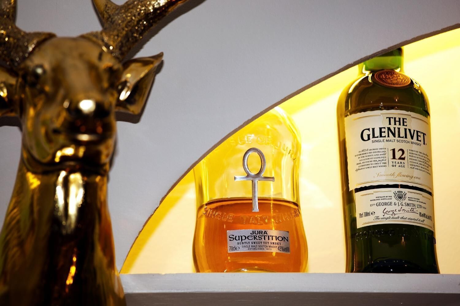 Une bouteille de whisky The Glenlivet et une bouteille de JURA Superstition.