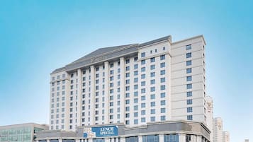 Un immeuble abritant un hôtel à plusieurs étages, avec une grande enseigne indiquant « MENU DU MIDI » sur le niveau inférieur.