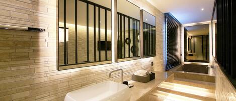 Un baño moderno con una bañera grande, un espejo y un diseño elegante.