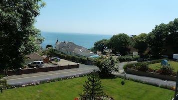 A residential area with a view of the sea, houses, and a parking lot.