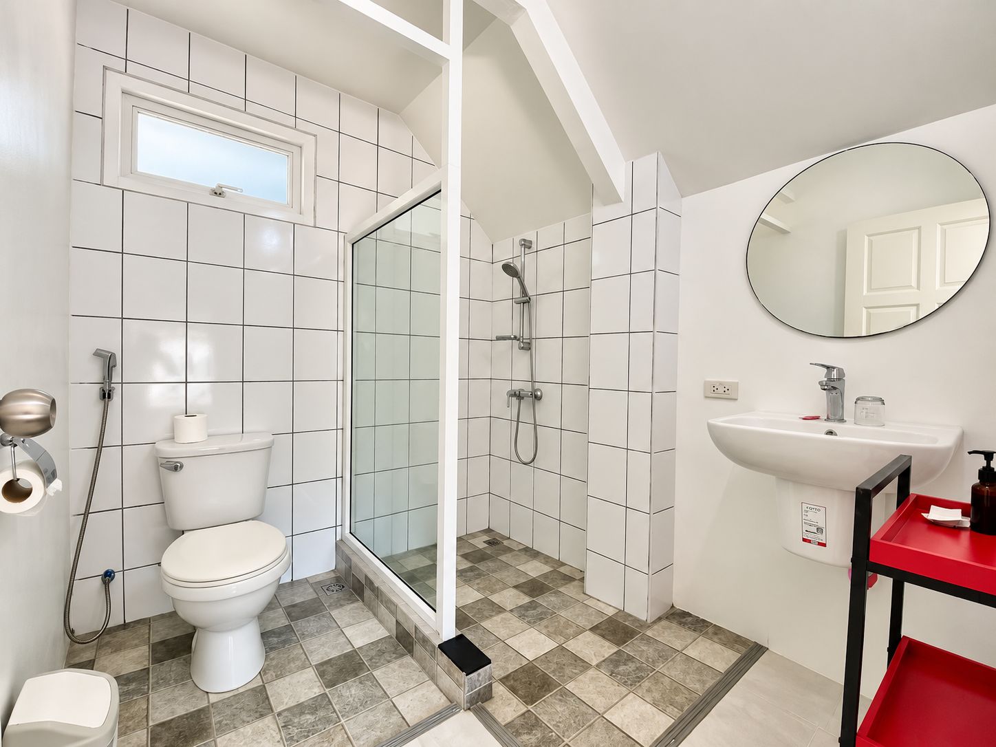 A bathroom with a toilet, shower, and sink.