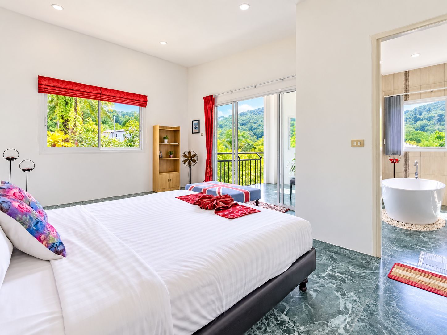 Un dormitorio moderno con una cama grande, vistas a zonas verdes, un balcón y un baño con bañera.