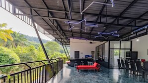 A modern interior with a balcony, a red sofa, and a bar area. - Villa Nap Dau 10 Bedrooms (Chalong)