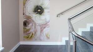 A staircase with a metal handrail and a wall with a floral mural. - Pensjonat Azul (Kolobrzeg)