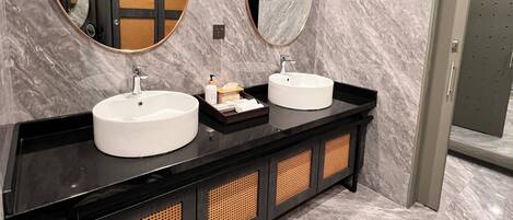 Un baño moderno con dos lavamanos, un espejo y un mueble de tocador con paneles trenzados.