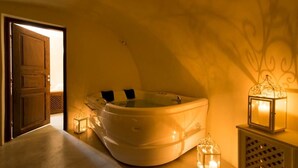 A spa room with a hot tub, a wooden door, and decorative lanterns.