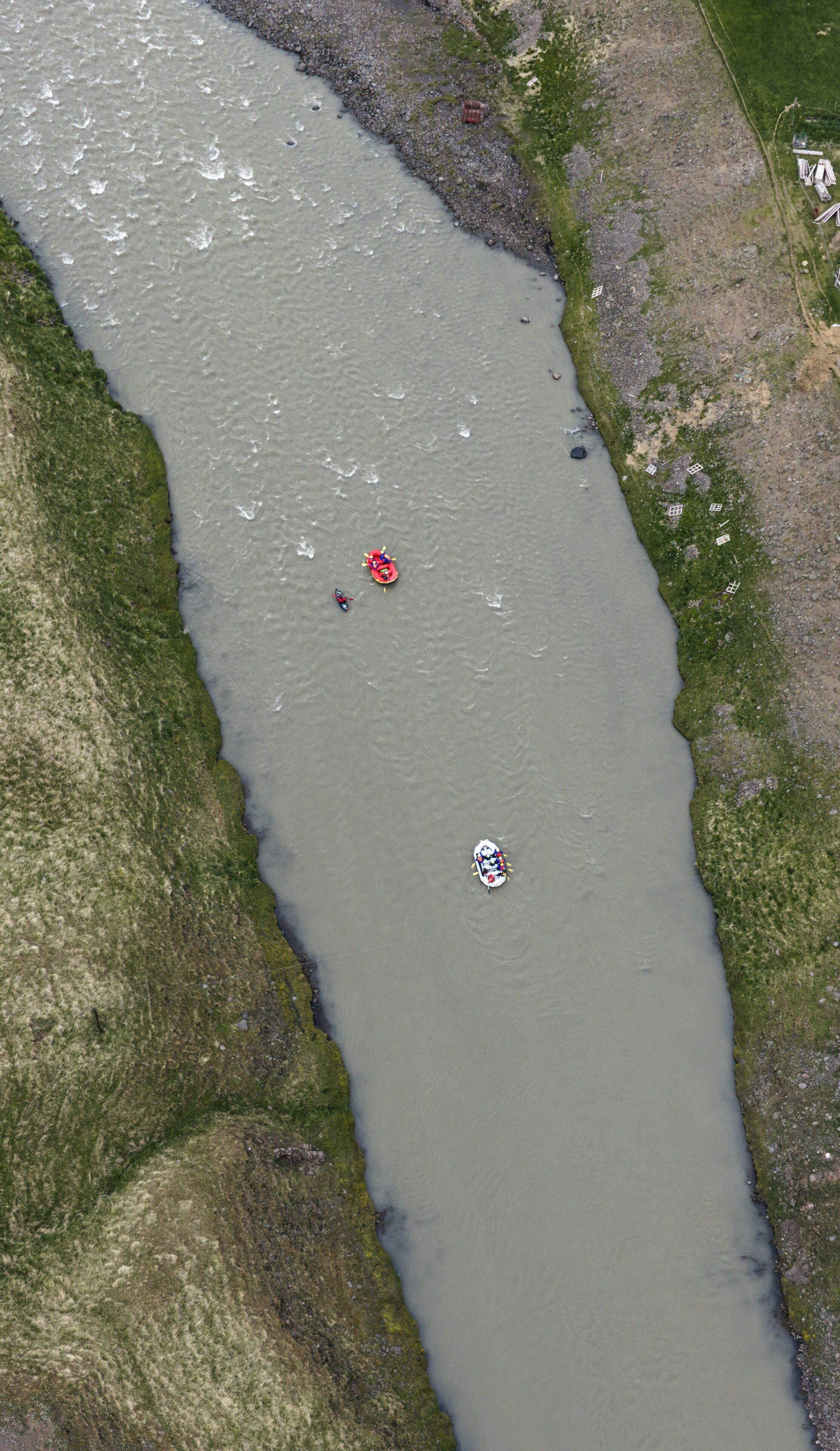 A river with boats and a small settlement along the banks.