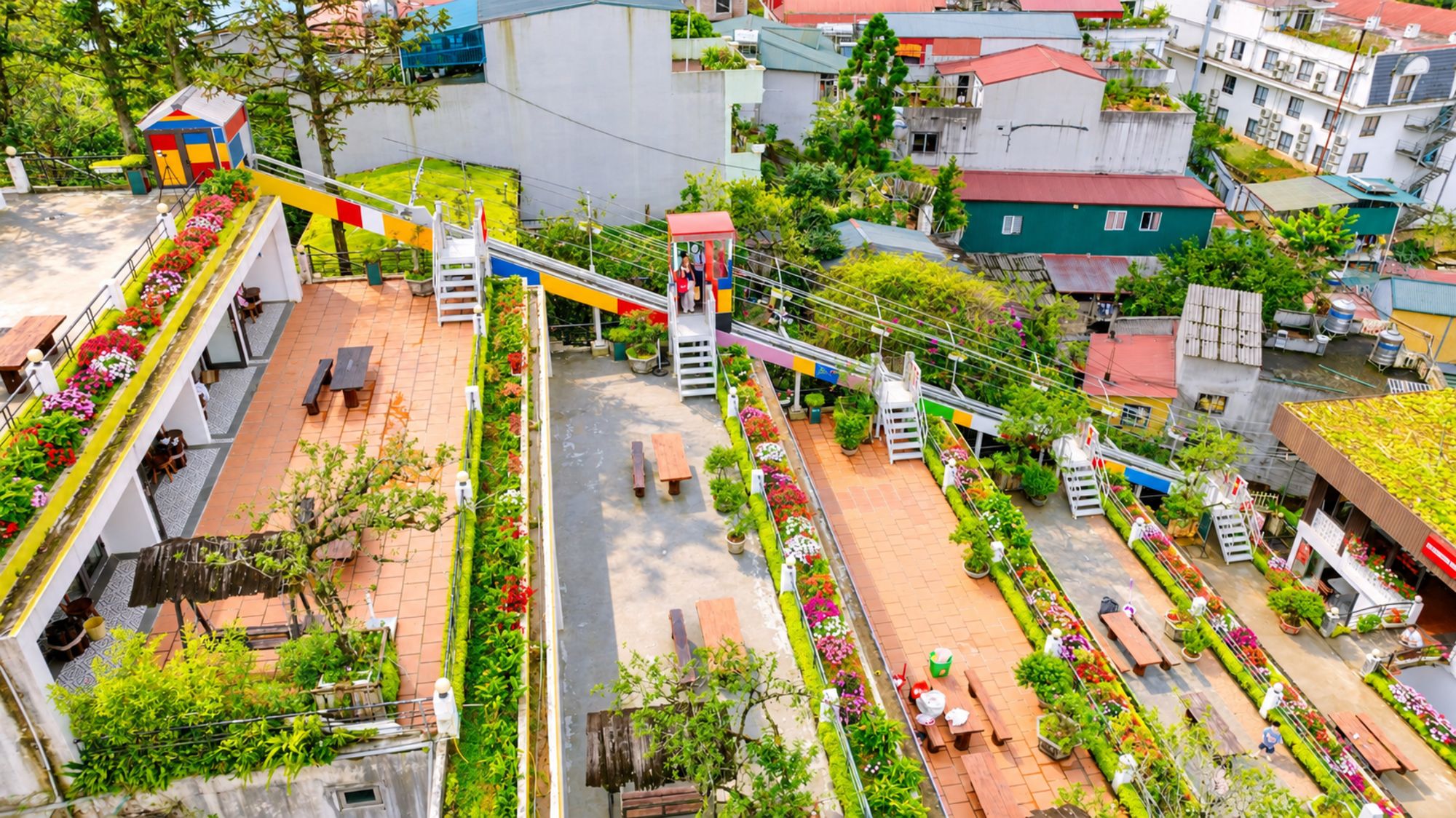 A rooftop garden with a zip line, potted plants, and outdoor seating.