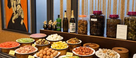 Un bufé con diversas opciones de comida, como carnes, huevos y ensaladas.