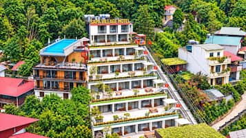 Un hotel de varios pisos con un letrero llamativo, balcones y una escalera que conecta las plantas.