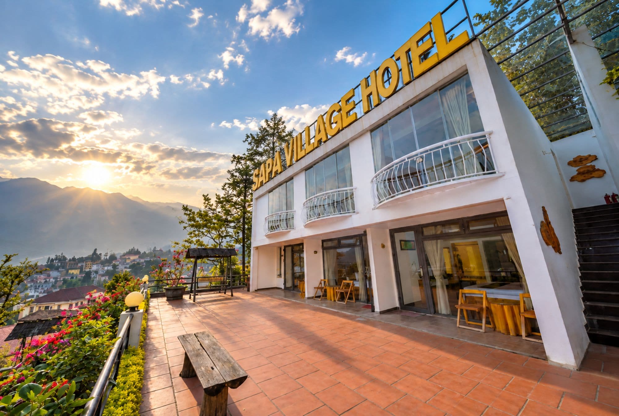 Un hotel de dos pisos con balcón y vistas a la montaña.