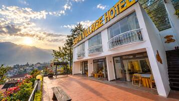 Un hotel de dos pisos con balcón y vistas a la montaña.