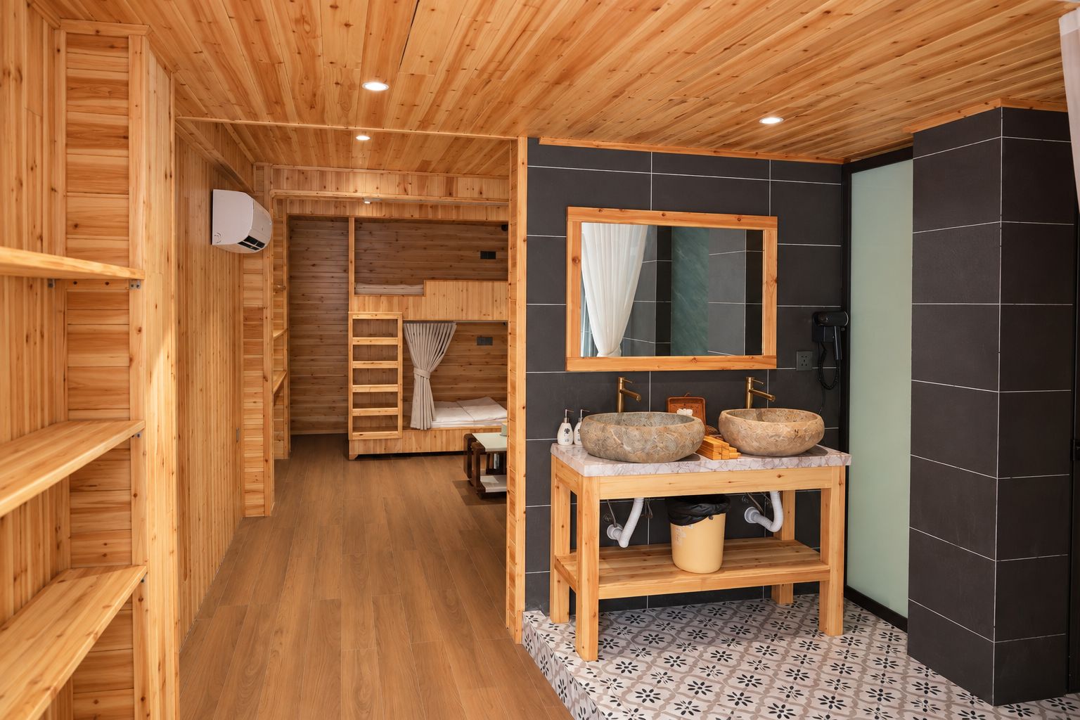A wooden interior with a bathroom featuring two stone sinks, a mirror, and a wooden vanity.