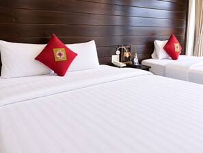 A hotel room with two beds, each with white bedding and red decorative pillows. - Sapa Village Hotel Sky Lounge & Spa (Sa Pa)