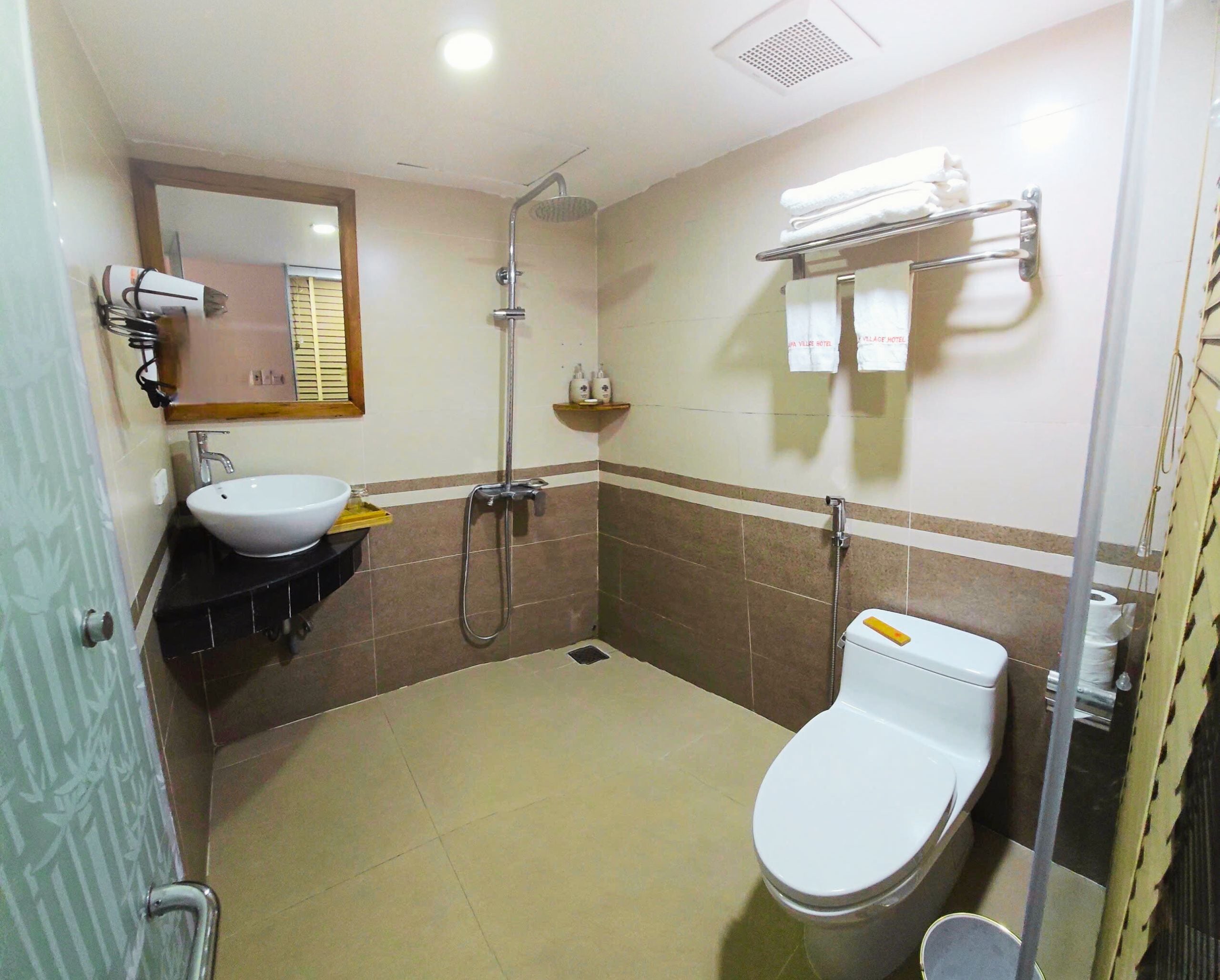 Ein Badezimmer mit Waschbecken, Toilette, Dusche und Handtuchhalter.