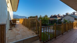A balcony with a wooden railing, a bench, and a view of the neighborhood and mountains. - YUAN QI WU Homestay (Shoufeng)