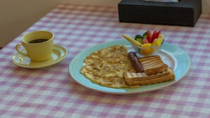 A breakfast table with a checkered tablecloth, a plate of food, a cup of coffee, and a tissue box. - YUAN QI WU Homestay (Shoufeng)