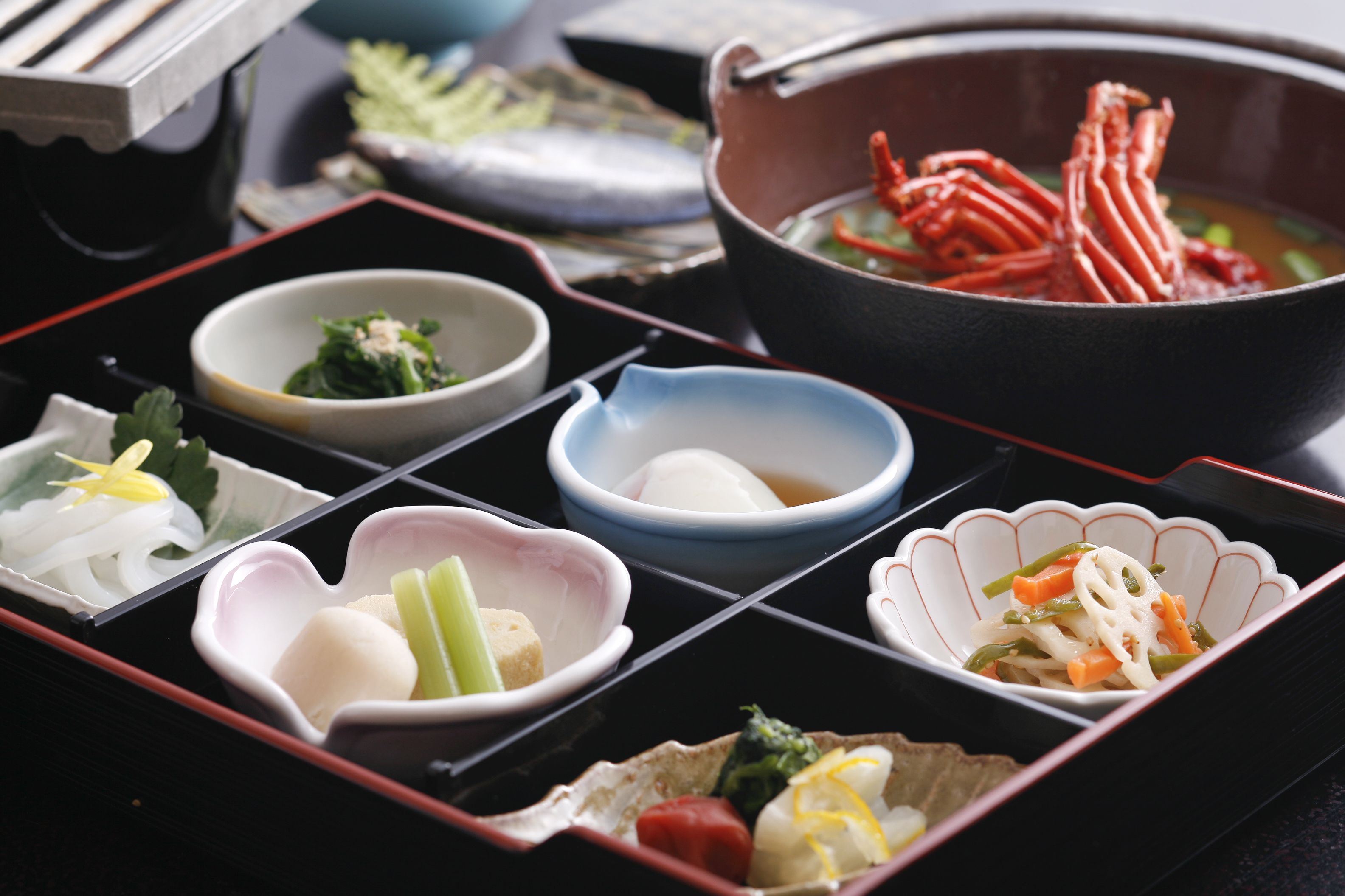 A traditional Japanese meal with various dishes in separate compartments.