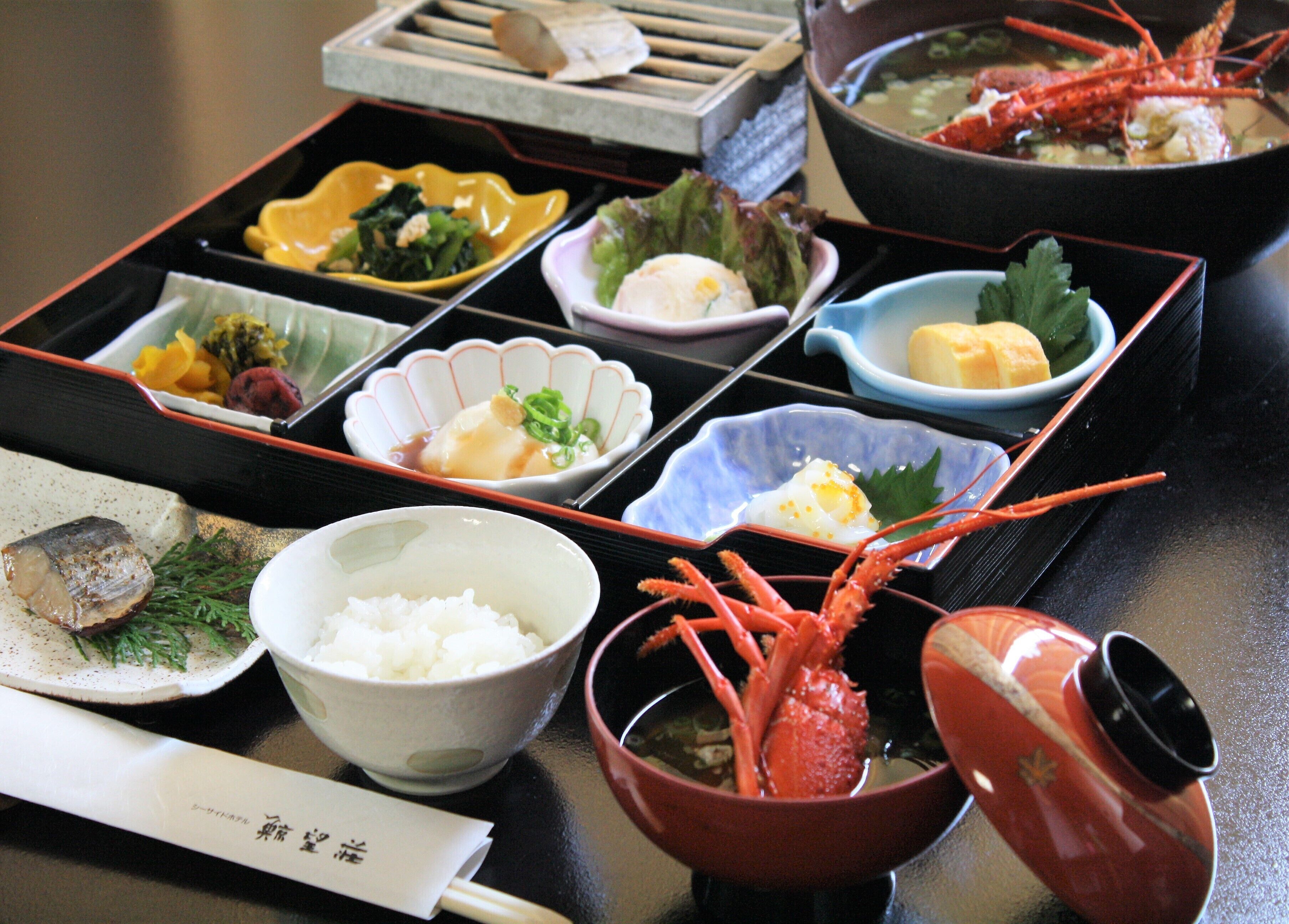 Un repas japonais traditionnel composé de différents plats, notamment du riz, des fruits de mer et des légumes.
