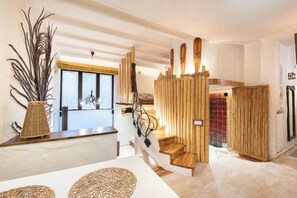 Un intérieur moderne avec un escalier, un comptoir d’accueil et une plante décorative.