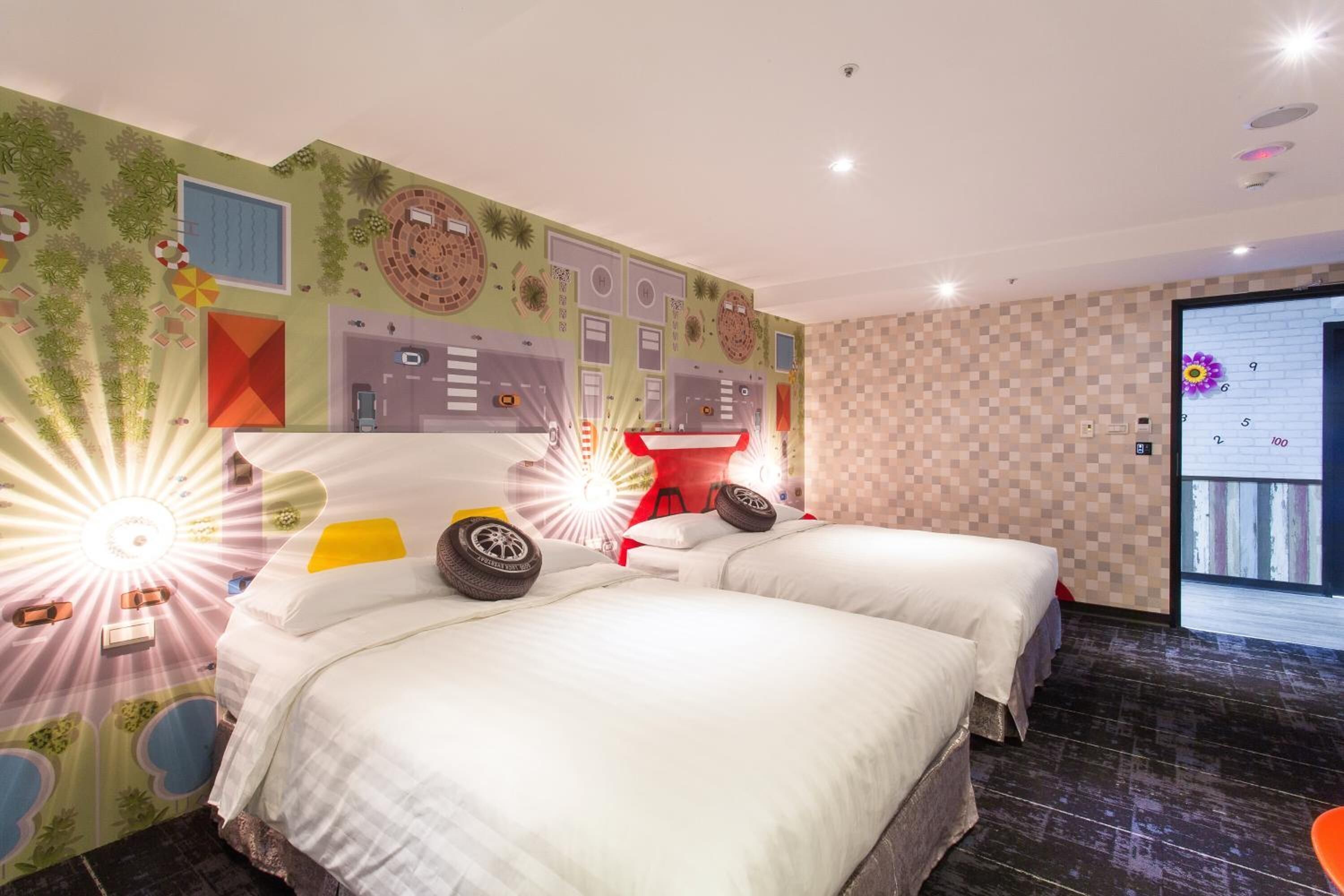 Een hotelkamer met twee bedden, een rode tafel en een groot raam.