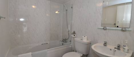 Un baño con bañera, inodoro y lavabo.