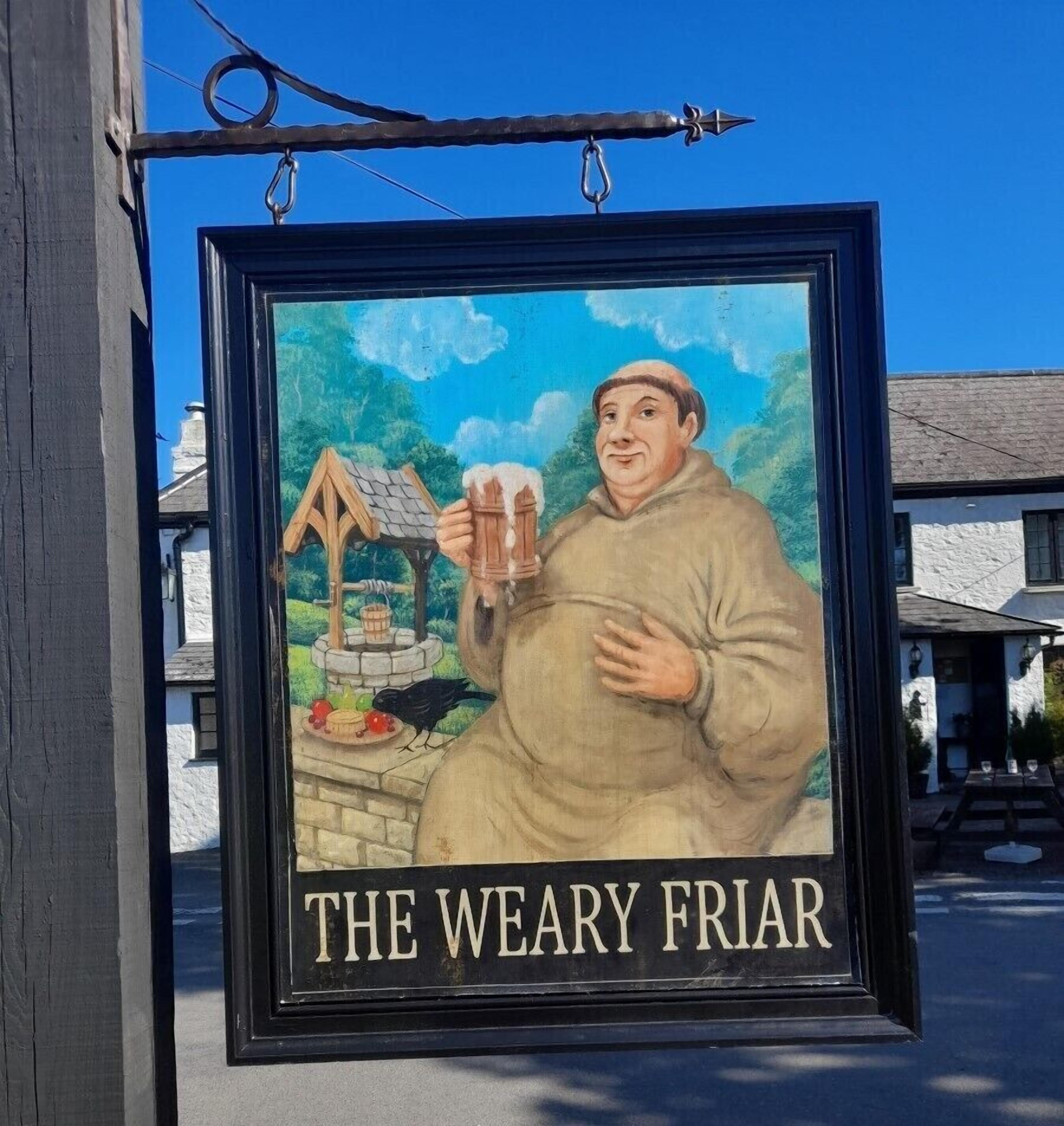A framed sign with a man holding a beer mug and a bird, titled "THE WEARY FRIAR".