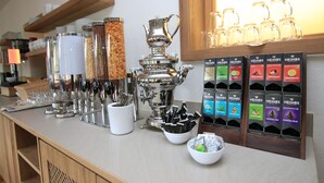 Een aanrecht met een koffieapparaat, kruidenvoorzieningen en een theeshow.