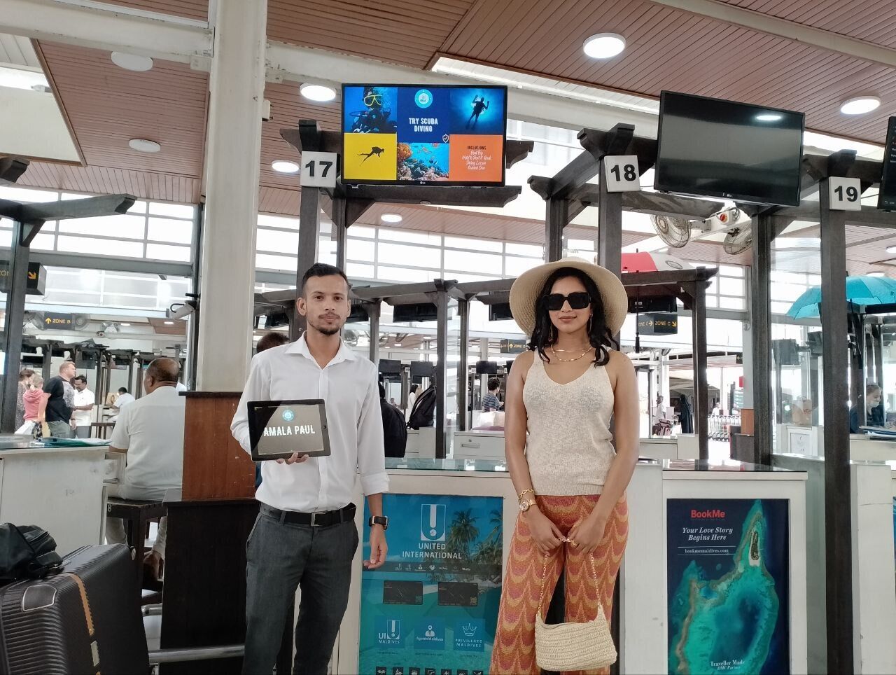 Un hombre y una mujer están frente a un mostrador de boletos en un aeropuerto.