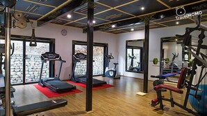 Ein Fitnessstudio mit Laufbändern, Ergometer und Gewichten.