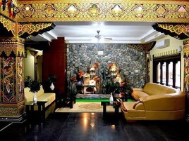 Una habitación con pared de piedra, un sofá, chimenea y elementos decorativos.