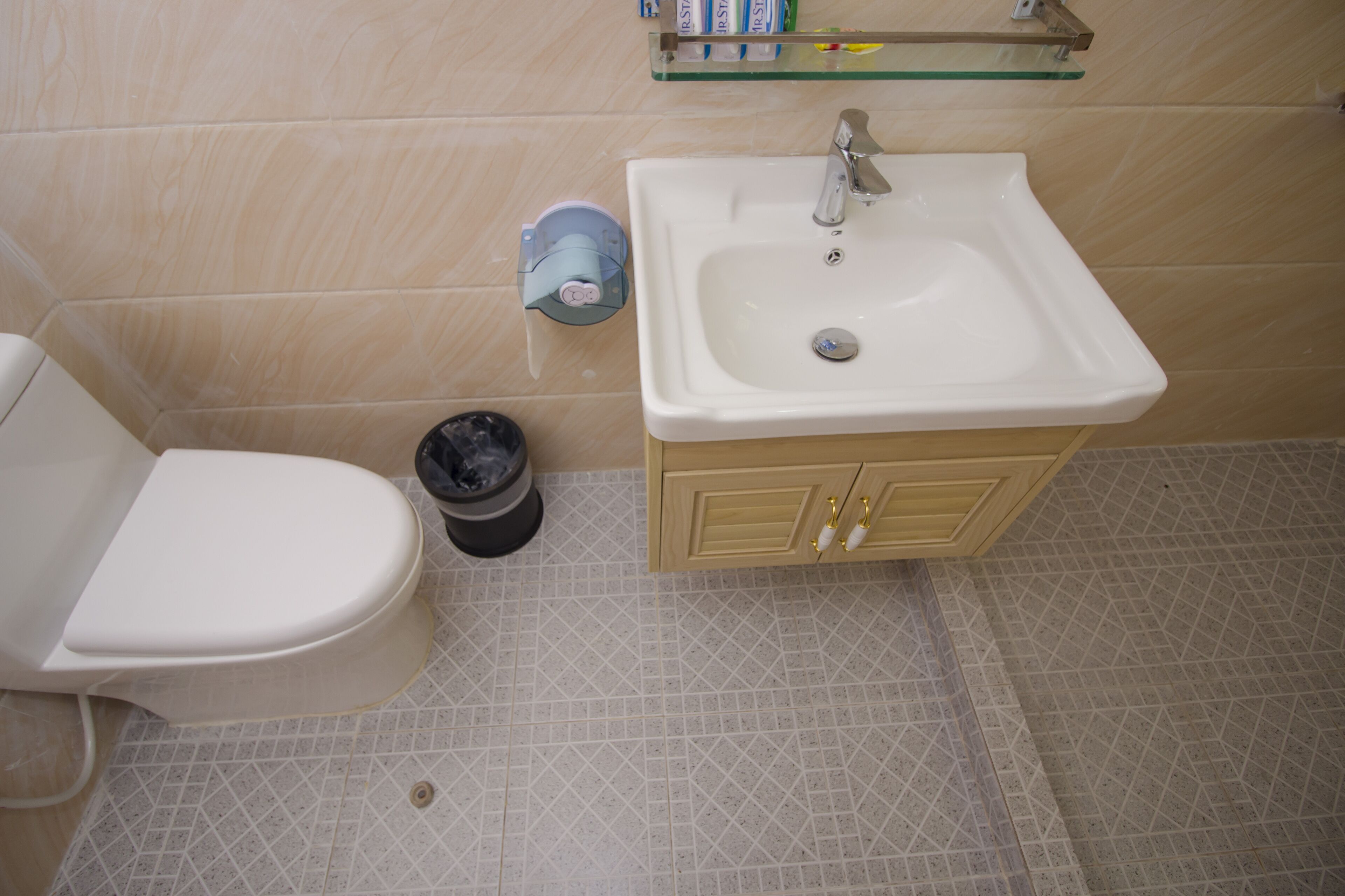 Une salle de bain avec des toilettes, un lavabo et un meuble de rangement.