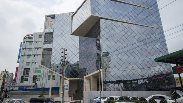 Um edifício moderno com fachada de vidro e entrada visível.