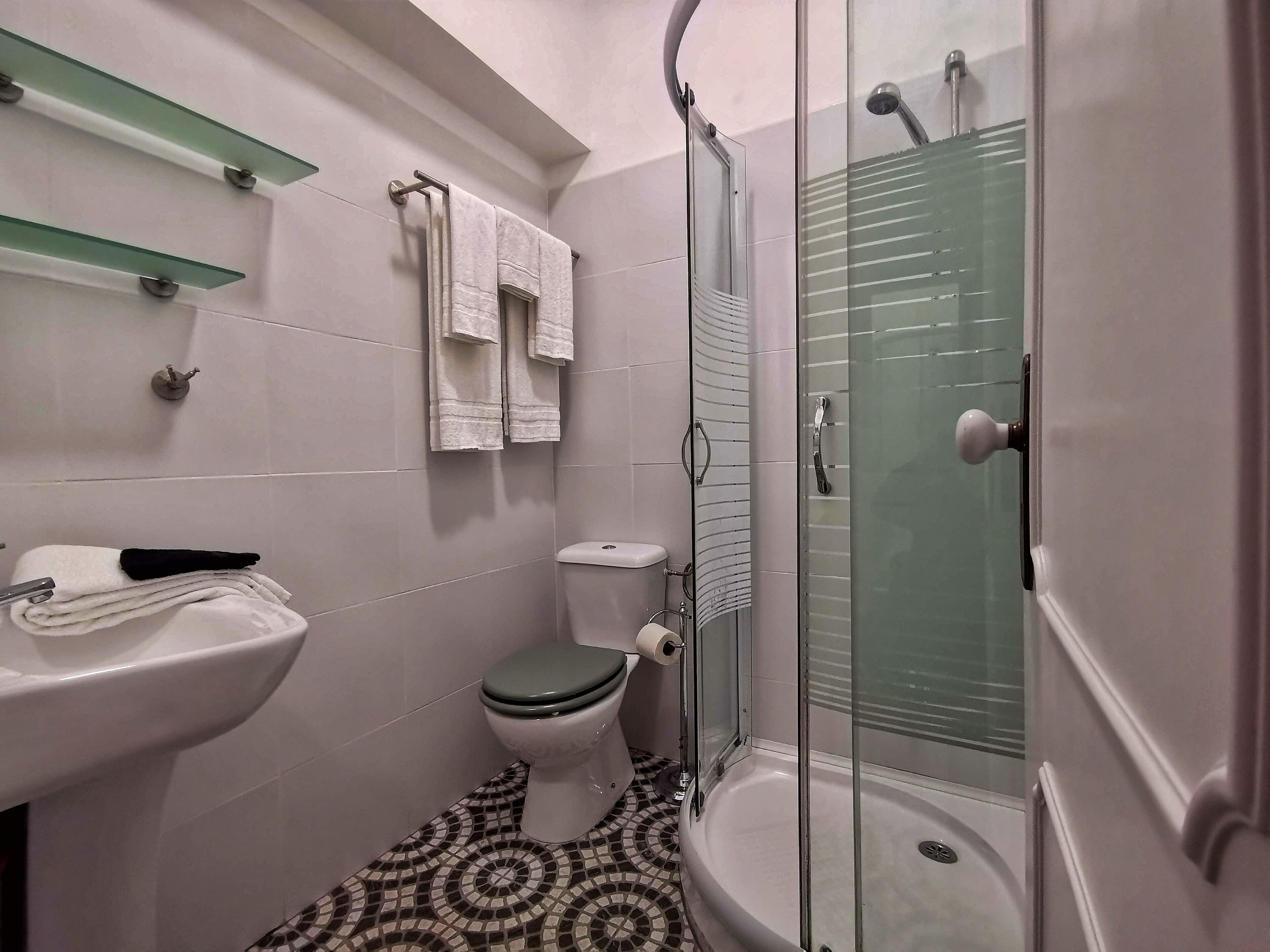 A bathroom with a toilet, sink, and shower.