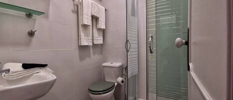 A bathroom with a toilet, sink, and shower.
