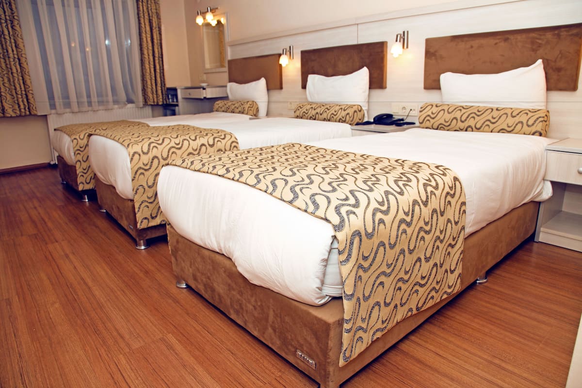 Une chambre d’hôtel avec deux lits, un plancher en bois et un design moderne.