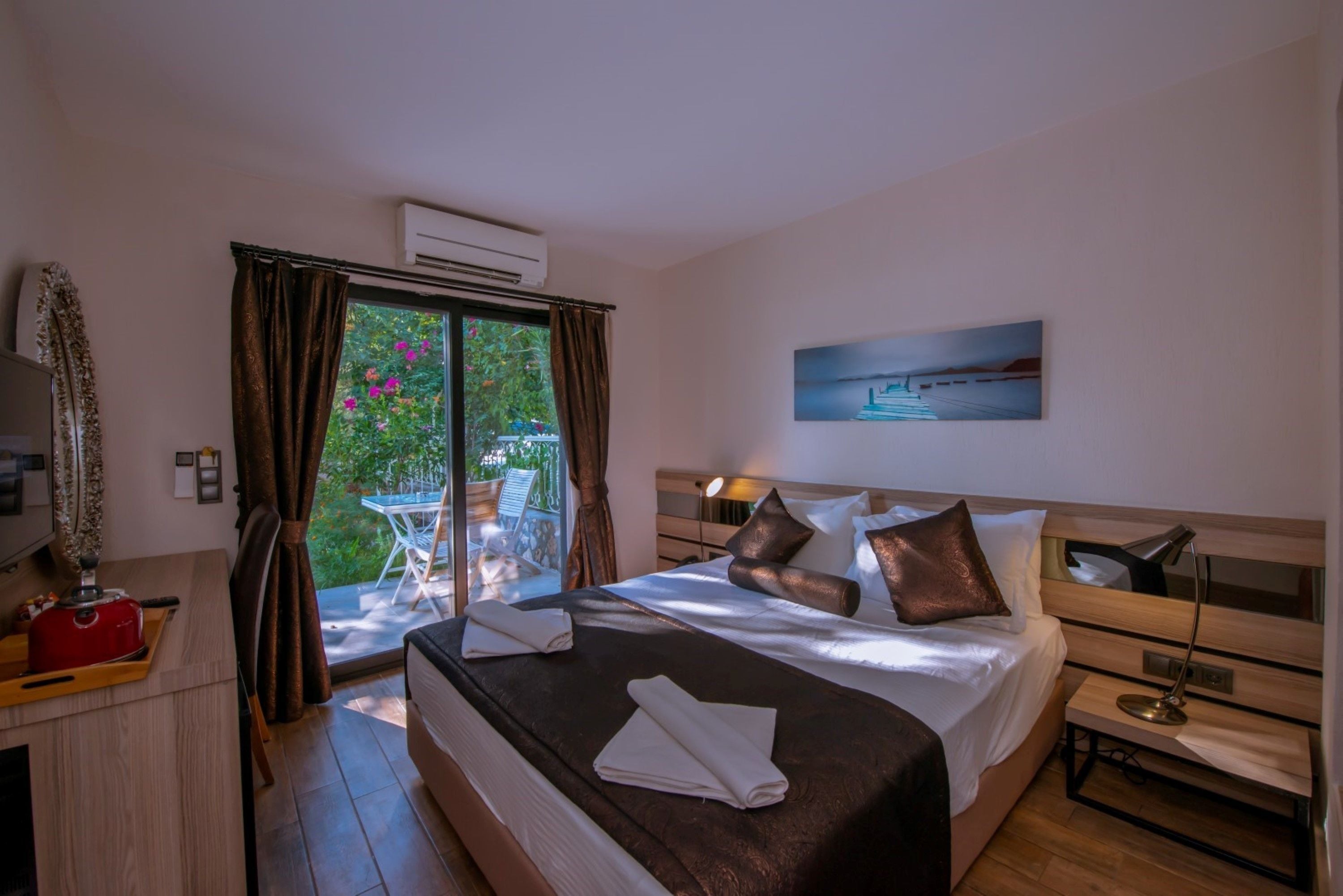 A hotel room with a bed, a desk, a chair, and a view of the outdoors.