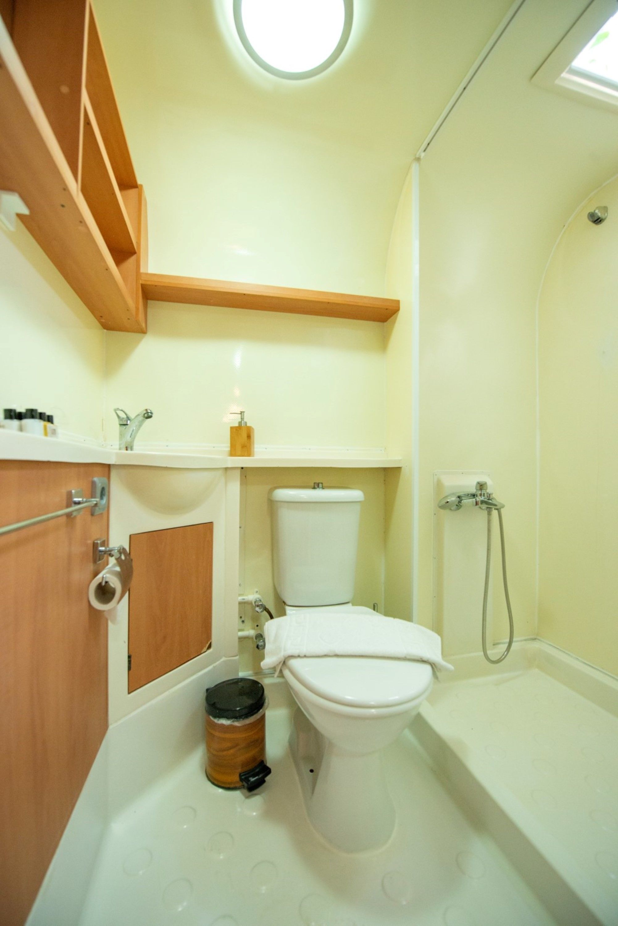 A compact bathroom with a toilet, sink, and shower.