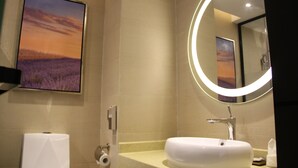 A modern bathroom with a sink, mirror, and toilet paper dispenser. - Lavande Hotel GZ LongDong Metro Station Branch (Guangzhou)