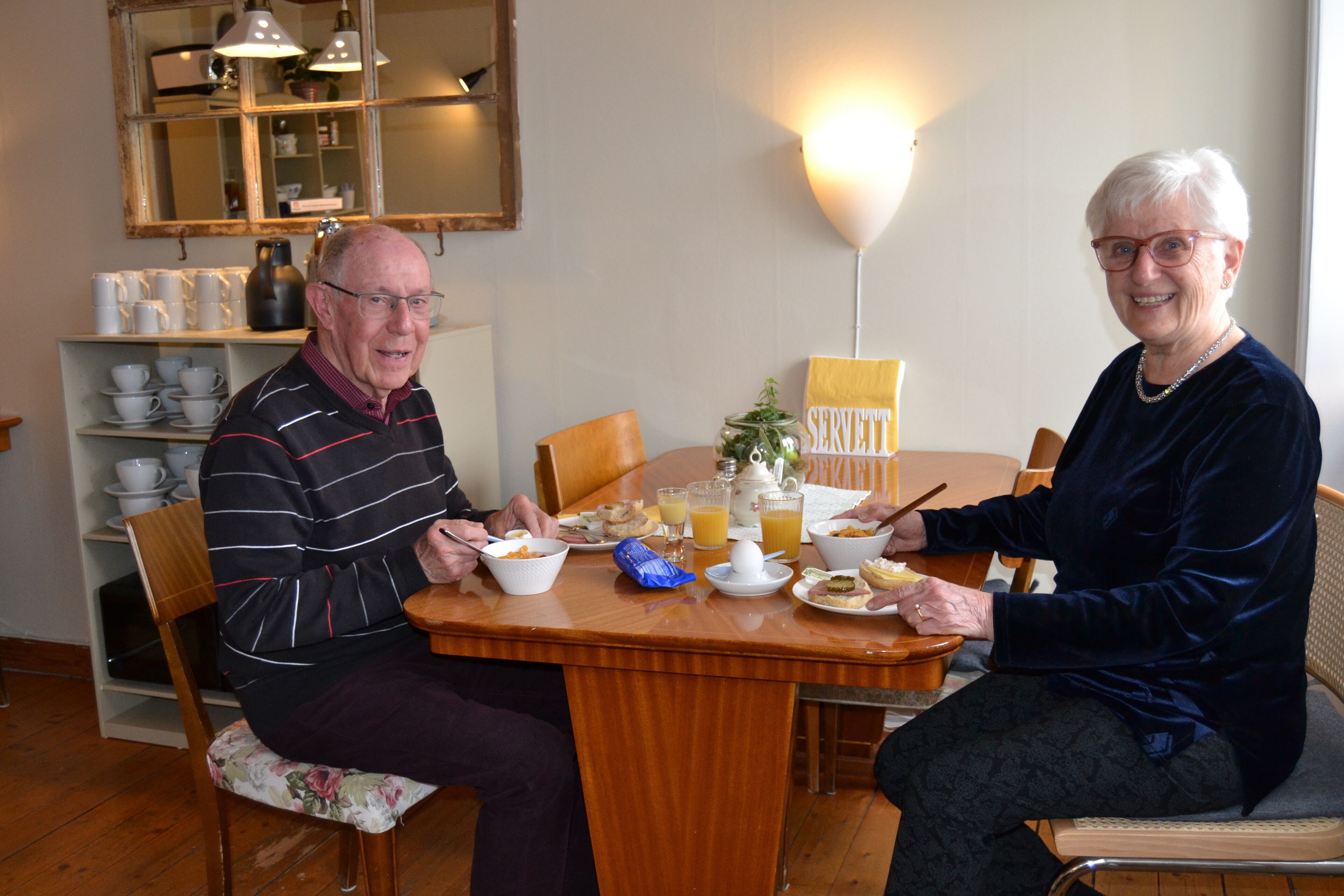 Una mesa de comedor con sillas, una cafetera y un letrero que dice "SERVETT".