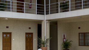 Een gebouw met een centrale binnenplaats, een tweelaags ontwerp en een overdekt balkon.