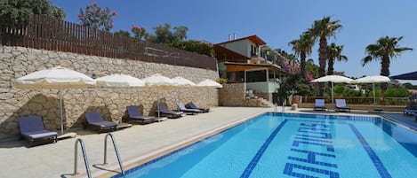 Piscine extérieure, parasols de plage, chaises longues